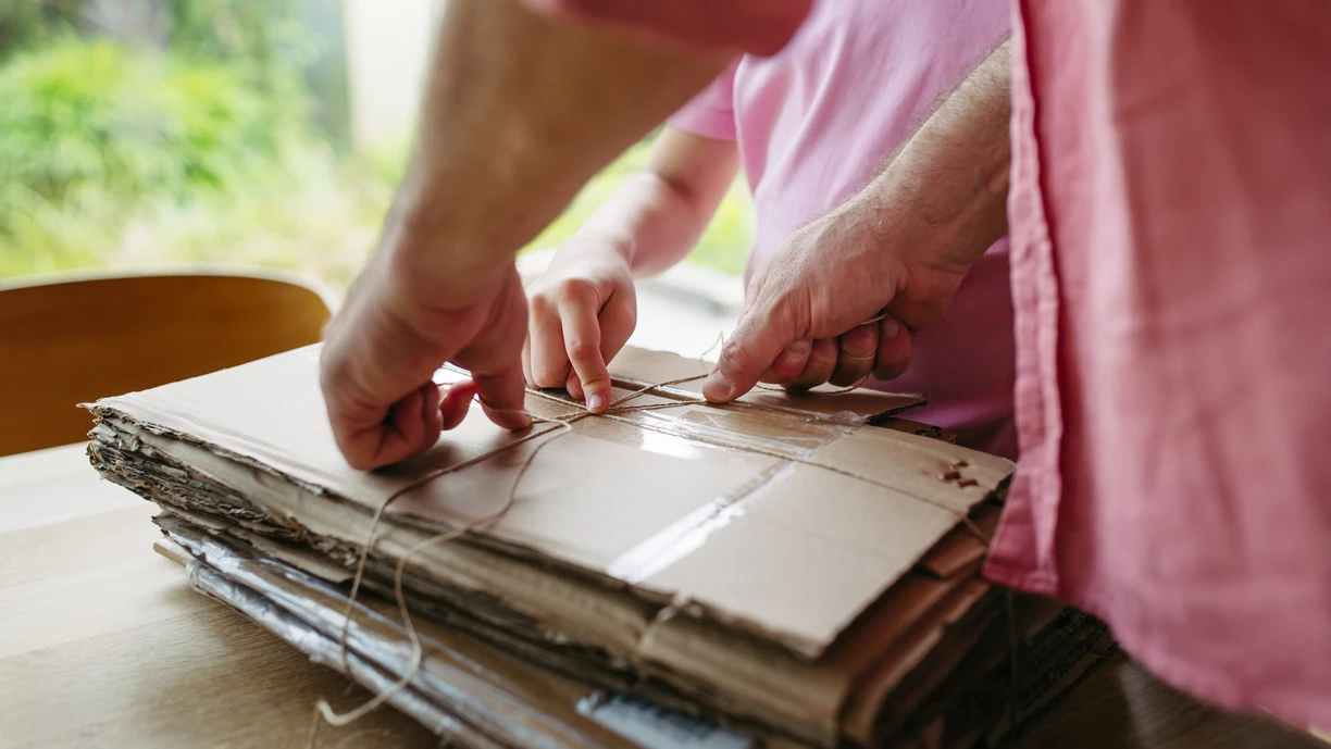 father and daughter preparing cardboard boxes for recycling