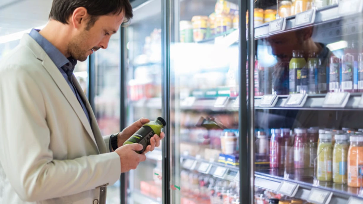 Man in a supermarket looking at a juice