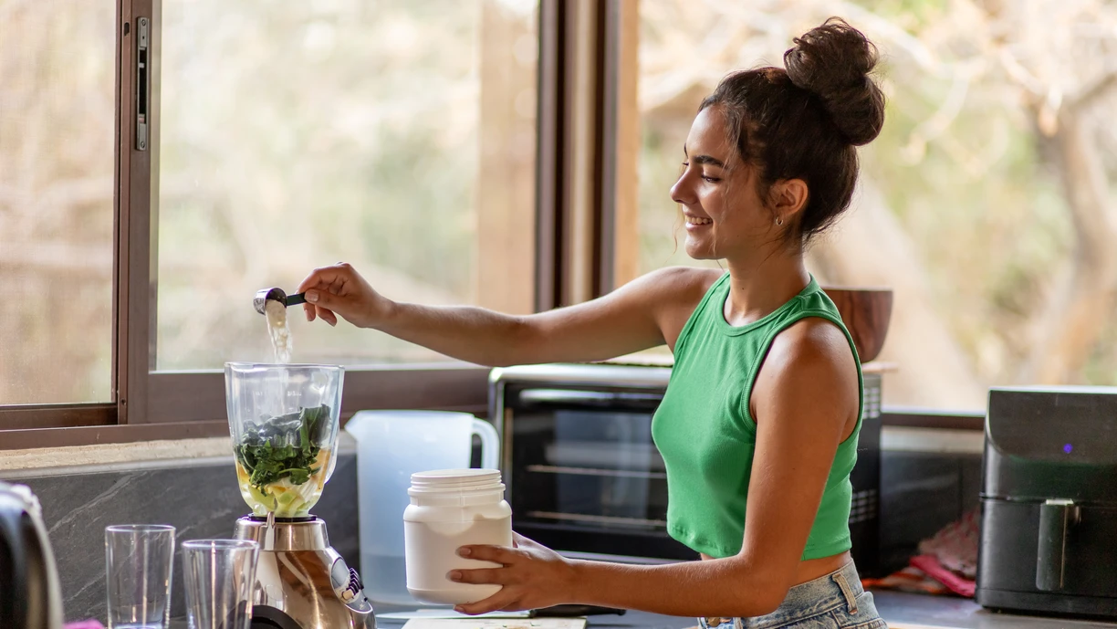 A lady making smoothie in the kitchen