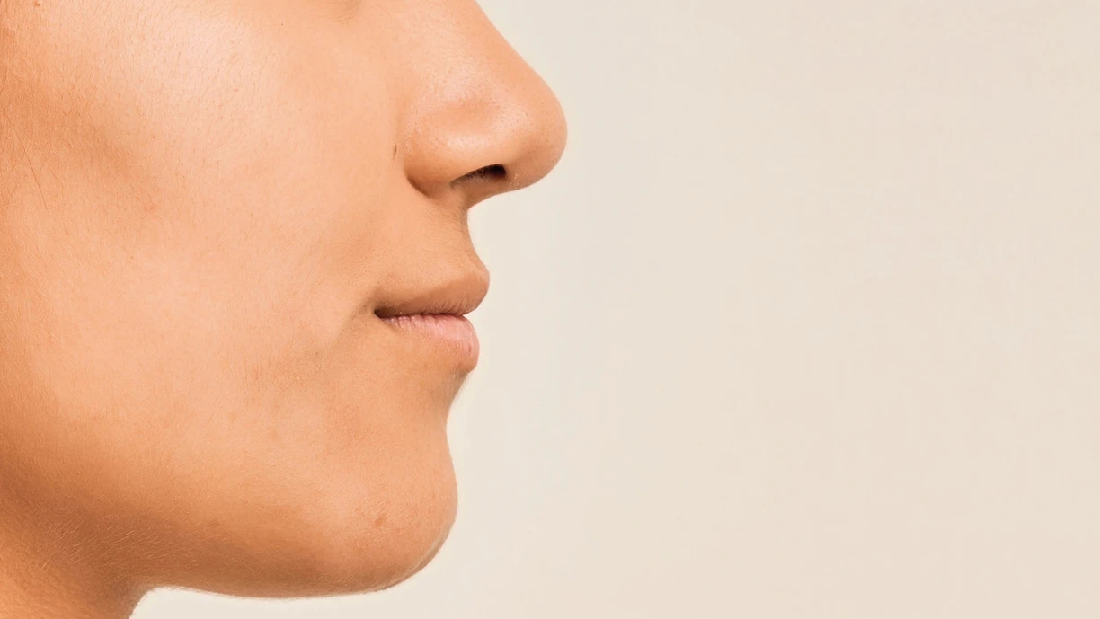 Close-up of a person's mouth and chin, representing sensory testing to improve cheese flavor through expert panel evaluations in controlled lab settings 