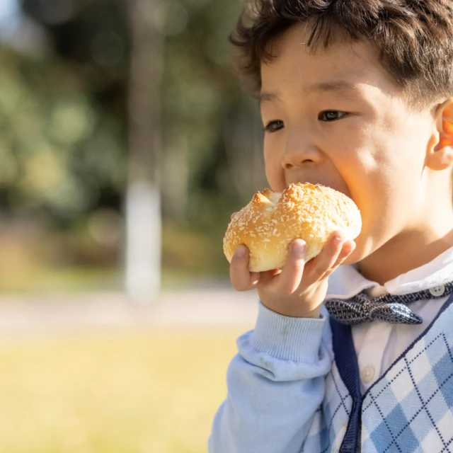 Kid eating a bun 