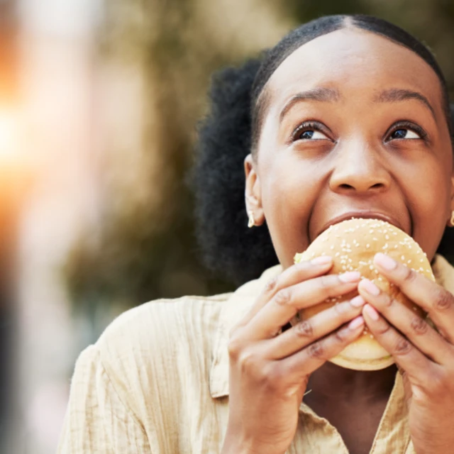 Woman_enjoying_a_tasty_burger_bun