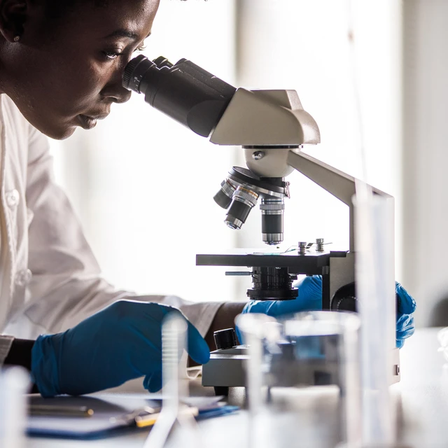 Scientist looking into a microscope