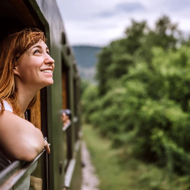 Smiling woman looking out of a window in a train