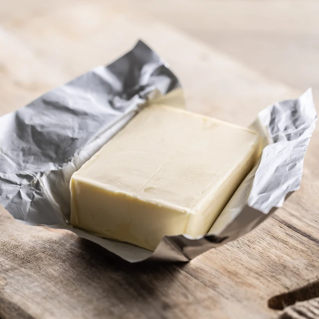 Whole butter unwrapped and placed on the cutting board