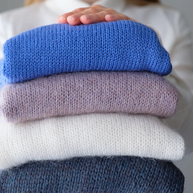 three jumpers in blue purple and white
