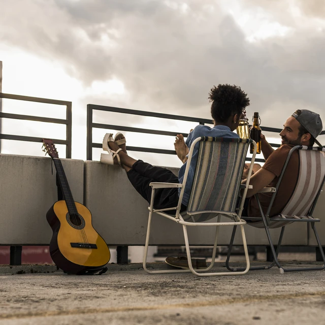 Friends drinking beer together on rooftop