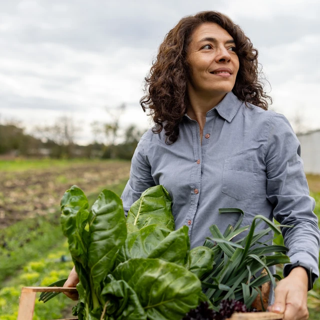 Latin American woman harvesting vegetables from her garden