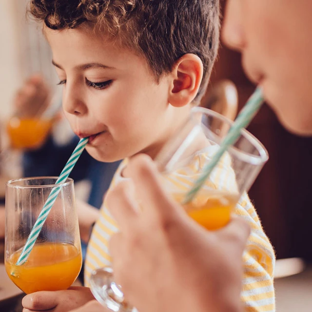 Boy_drinking_orange_juice_with_a_straw