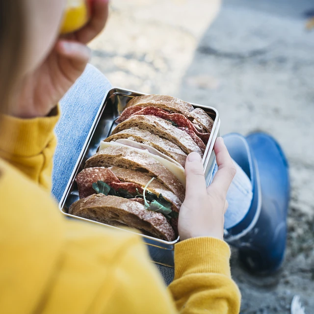 Girl in yellow clothing eating her lunch