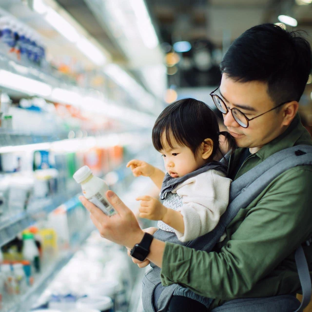 Young Asian father with cute little daughter at grocery