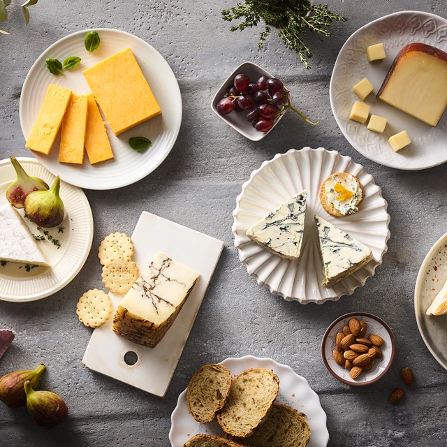 Elegant cheese platter with assorted cheeses, fruits, nuts, and crackers