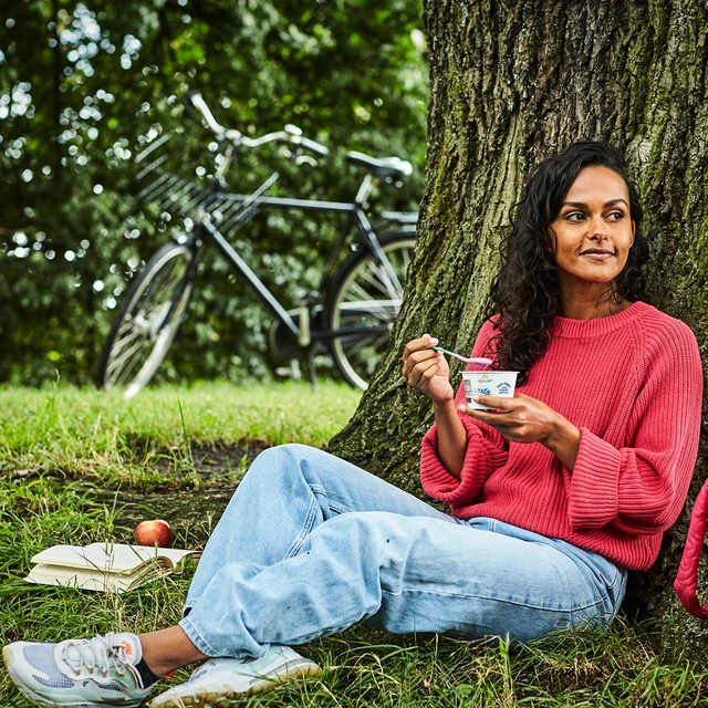 woman in forest eating yogurt
