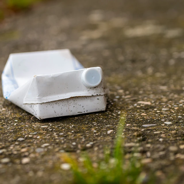 Flattened white carton on the ground