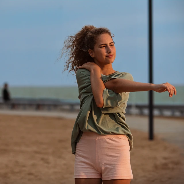 girl stretching at beach
