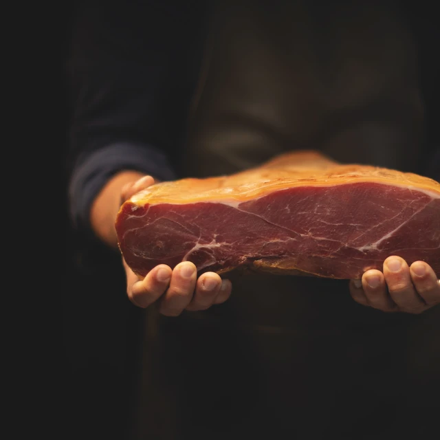 Man holding cured ham