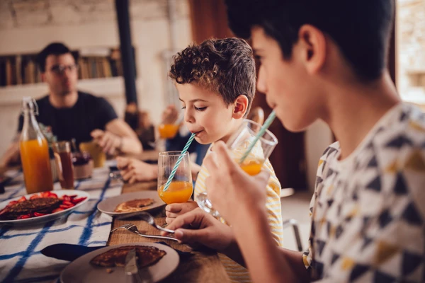Boys sipping on juices at table