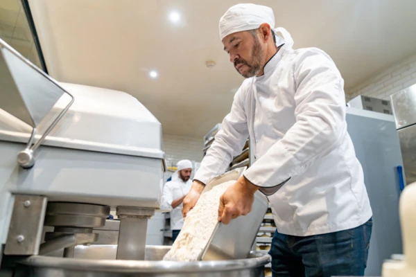 Man pouring flour in mixer 