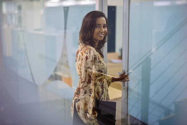 Girl smiling in yellow/brown shirt from side