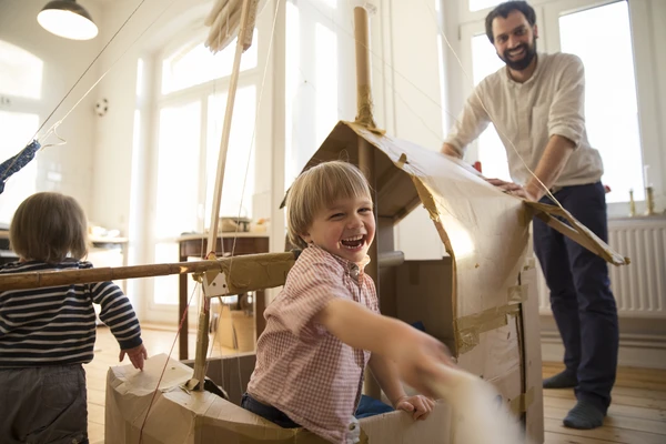 father and son playing with cardboard