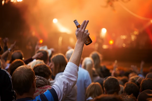 Hand holding beer at concert