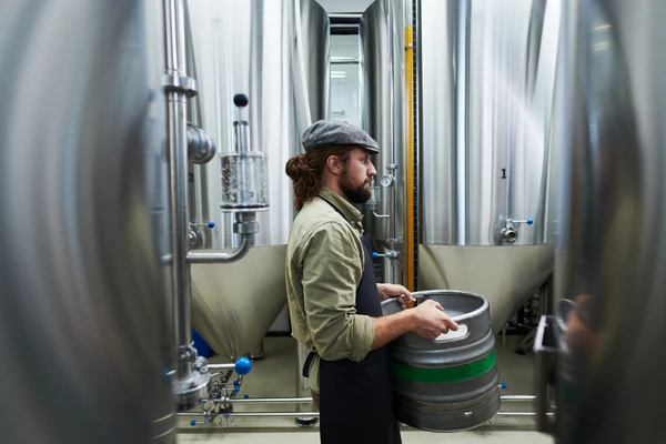 A man carrying large beer fustage