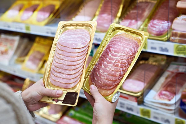 Woman-chooses-slice-of-ham-at-store
