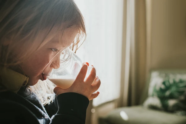 A close up of a girl drinking milk