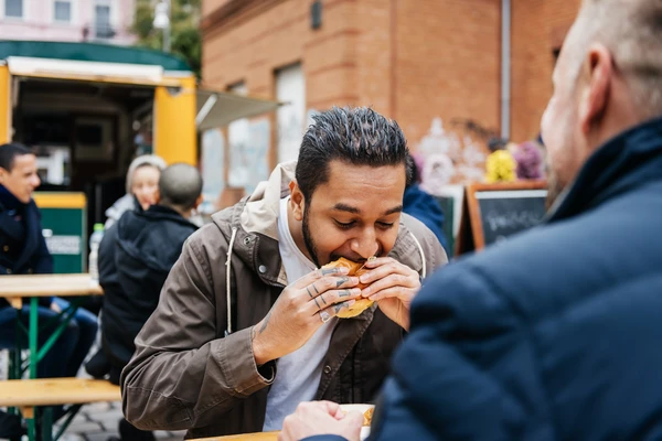 Hungry Man Eating Burger From Food Truck