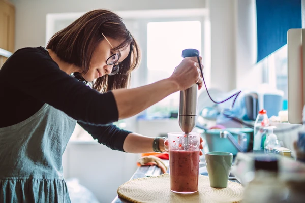 woman making fruit smoothie