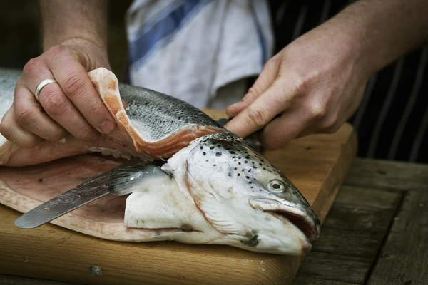 A chef cutting salmon out on a cutting board