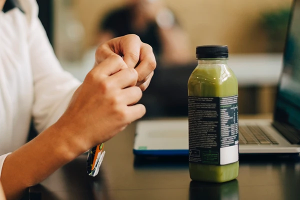 A lady sitting in front of computer eating
