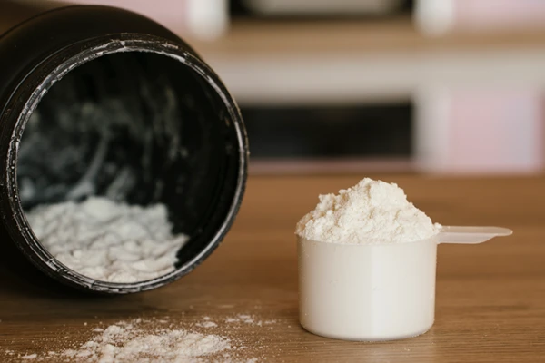 Measuring scoop of collagen powder on the kitchen counter at home close-up