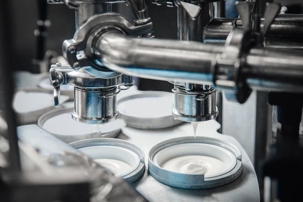 Yogurt production line with yogurt pots being filled 