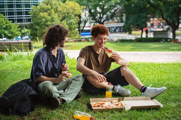 two men eating pizza