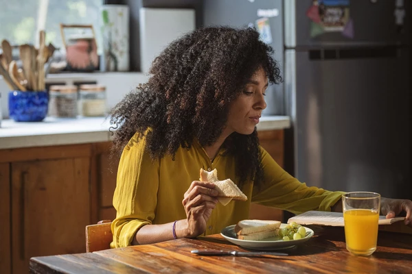 woman-eating-sandwich-in-kitchen