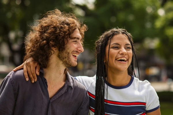Young woman and man laughing in a park