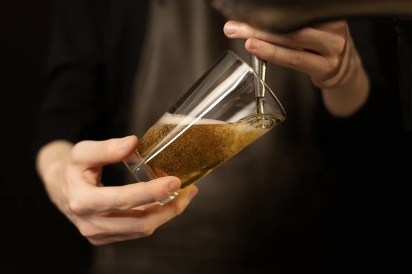 hand holding glass of beer