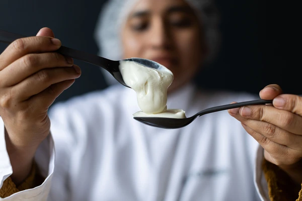 Woman holding spoons with yogurt