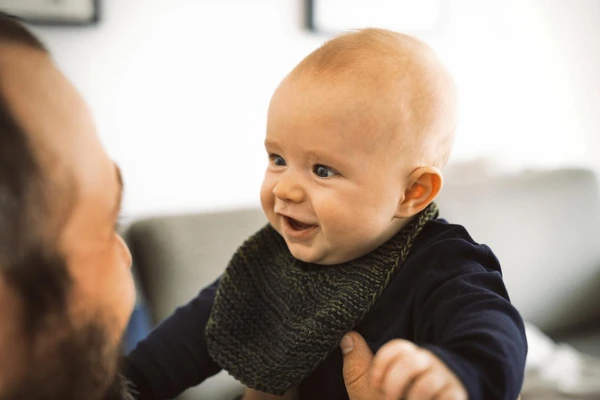 father holding smiling baby