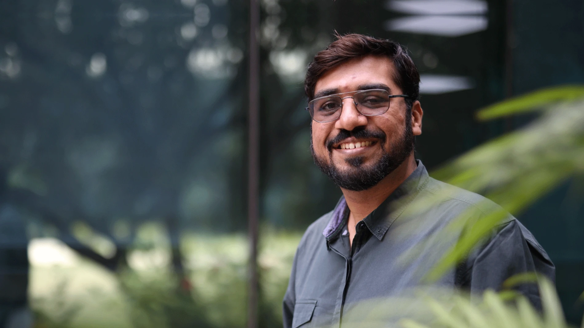 Man wearing a grey shirt, in a parc