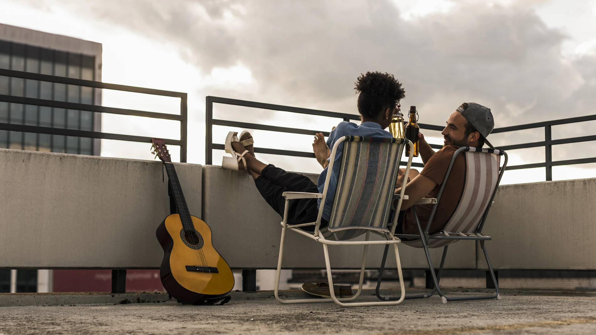 Friends drinking beer together on rooftop