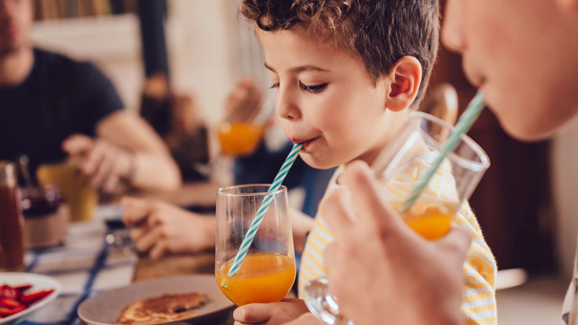 Boy_drinking_orange_juice_with_a_straw