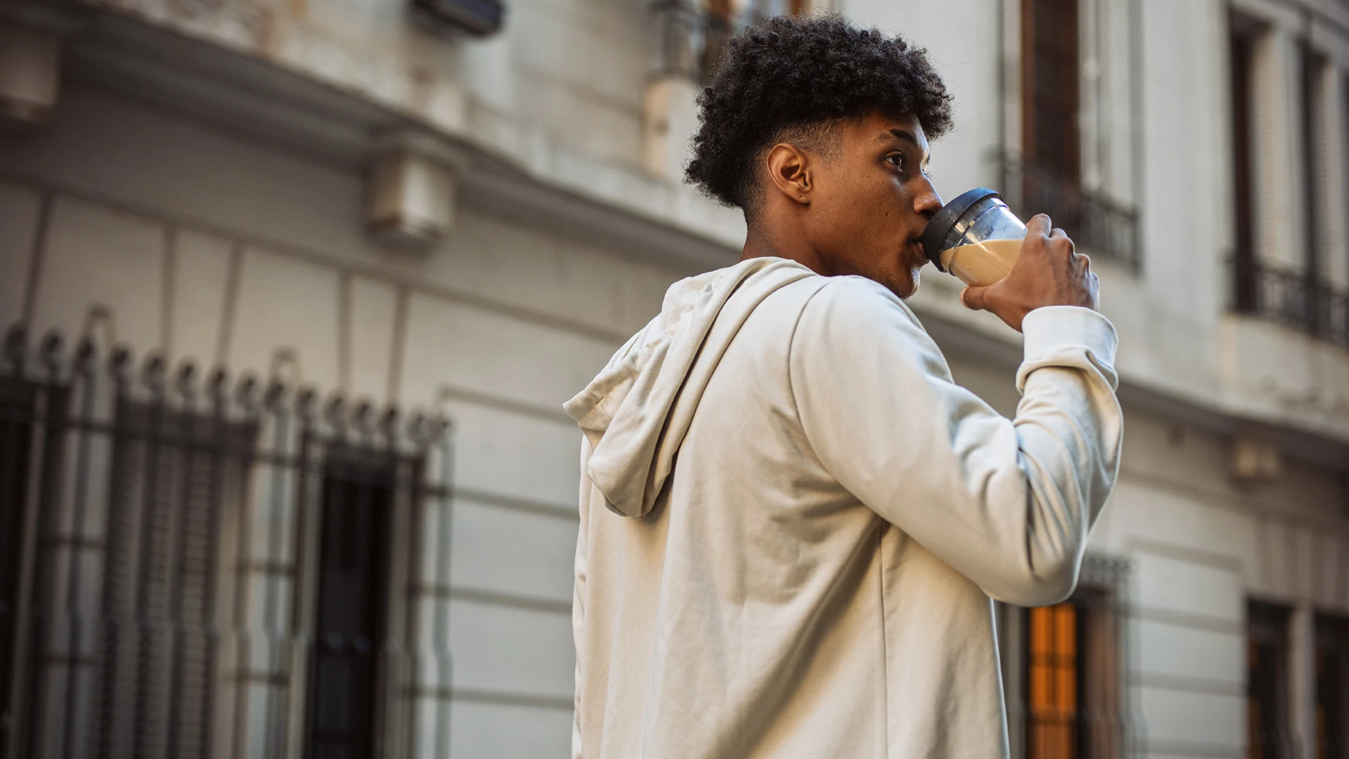 Man drinking plant-based latte outside