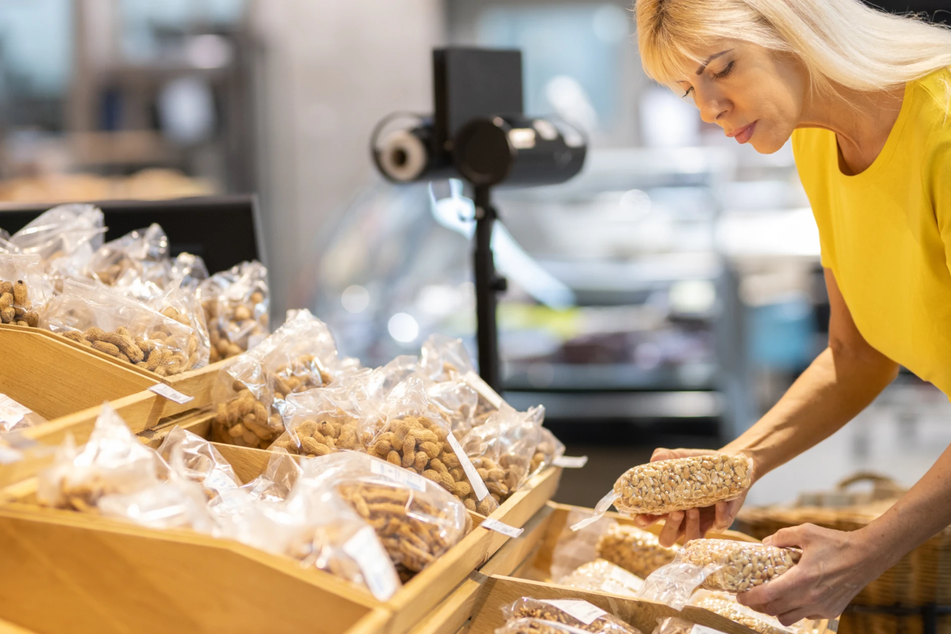Woman in the grocery store picking a packaged bread