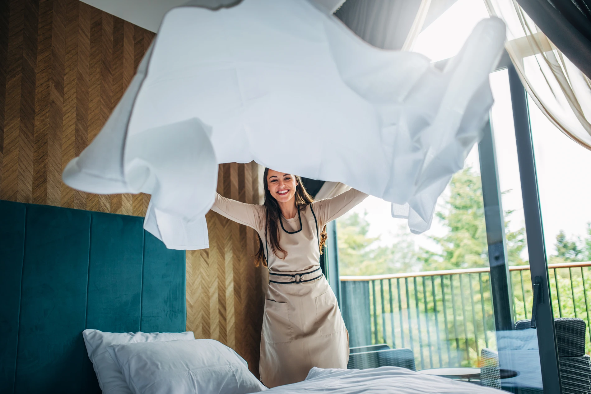 Housekeeper making the bed at a hotel