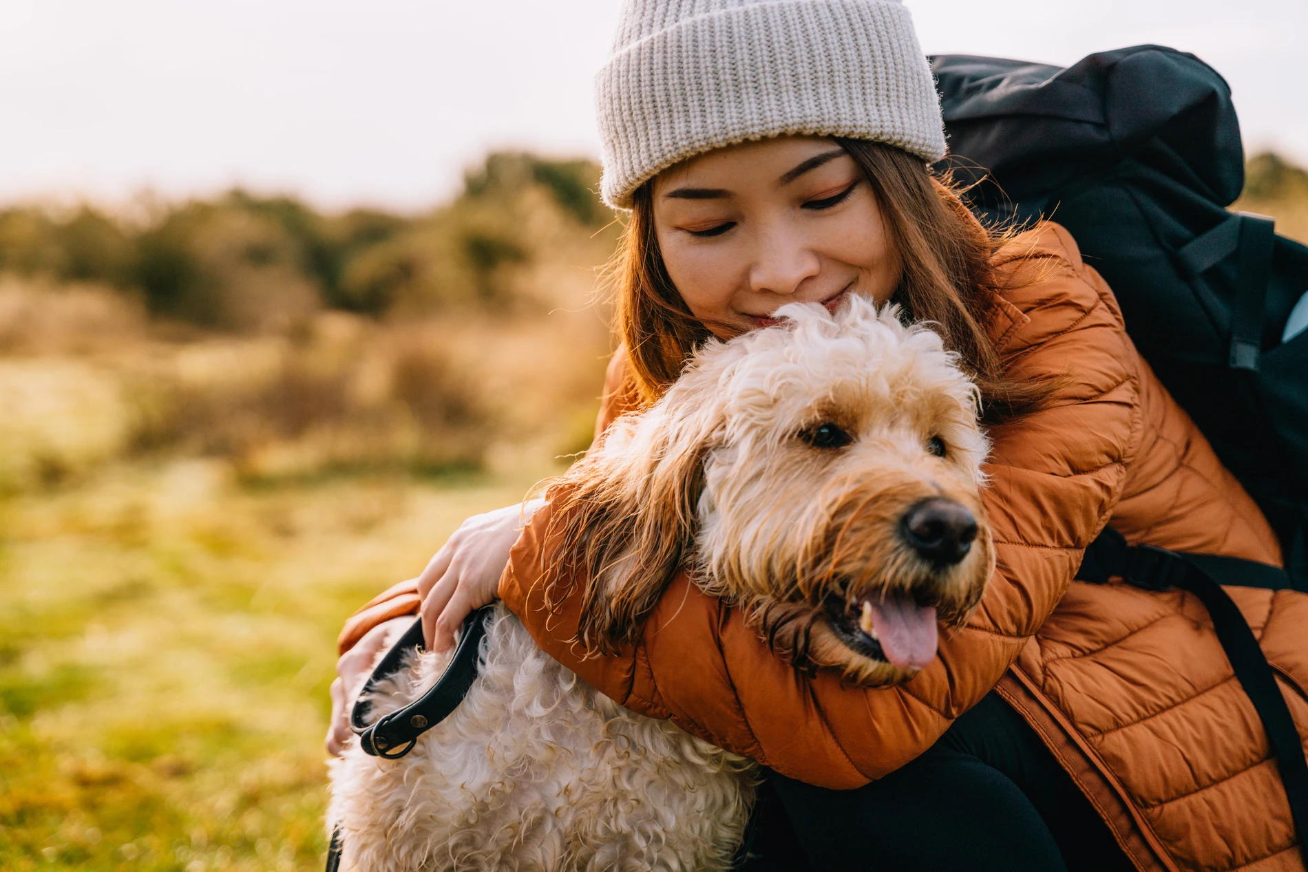 A pet owner hugging her dog outdoor