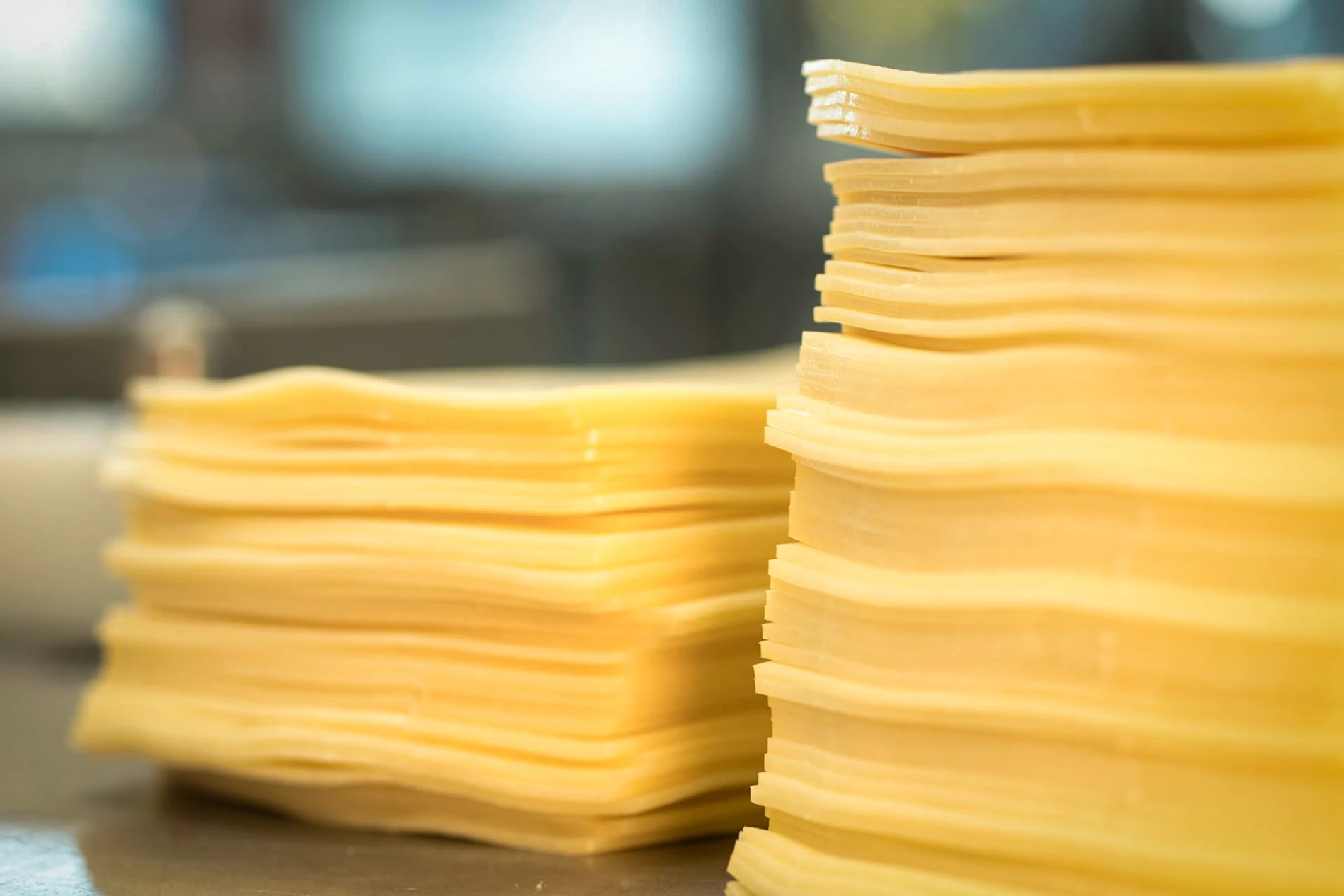 Two stacked piles of thinly sliced cheddar cheese,