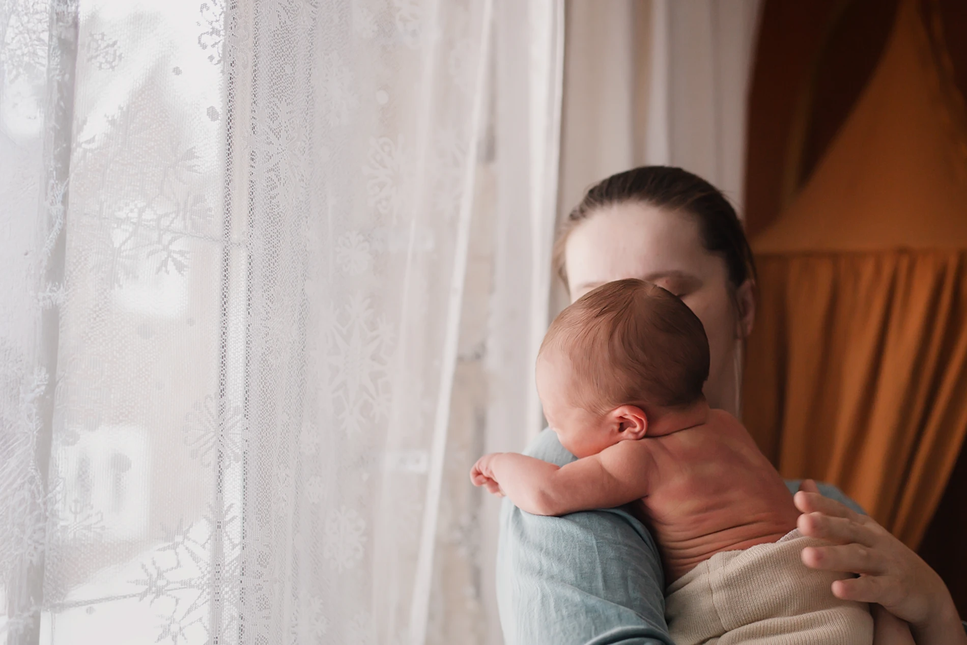 Mature mother comforting her newborn while crying